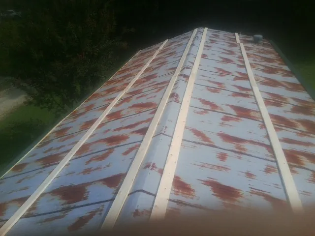 Rusted metal roof panels with new wood purlins before replacement — Storm Damage Roof Repair in Hildebran by Roofing Brothers