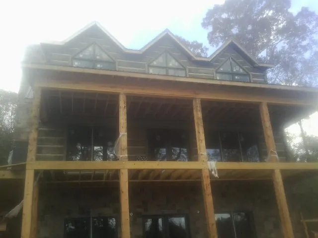 Dormers and porch framing on a large log home under construction — Roof Coating work by our crew in Hildebran