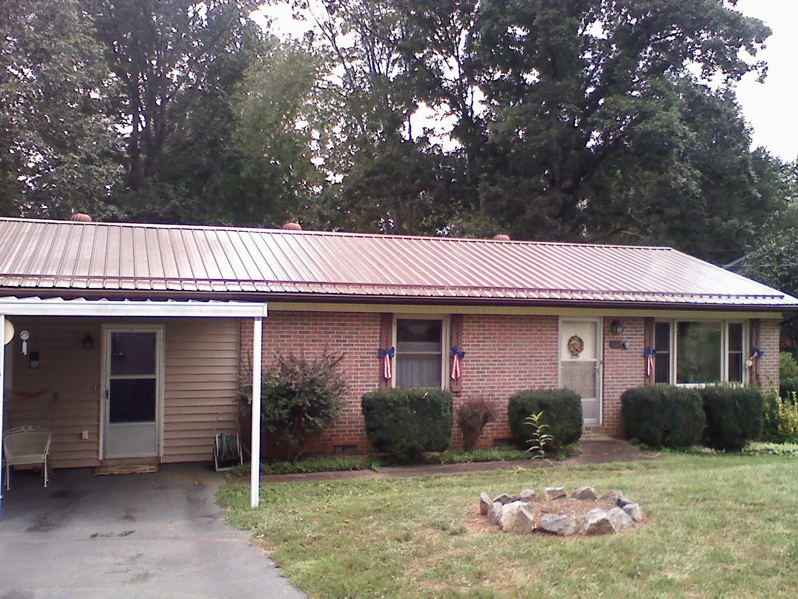 Bronze metal roof and carport on a brick ranch home — Roof Repair work by our crew in Hildebran