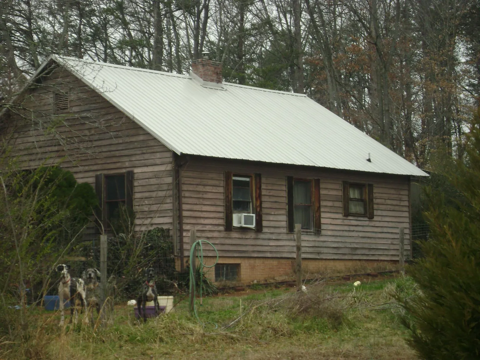 White metal roof on an old wood sided farmhouse, from a Metal Roof Installation job in Hildebran